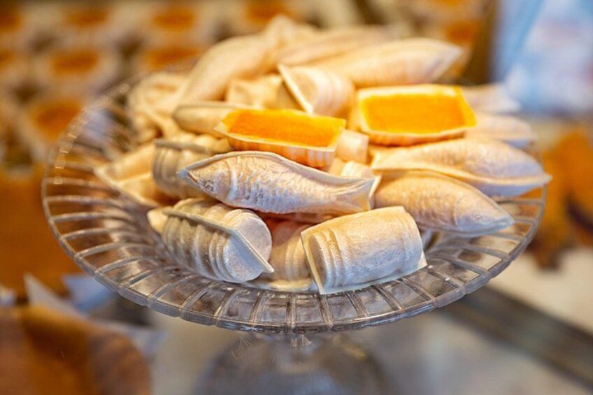 A glass plate with various pastries, including rolled dough and orange slices. 3