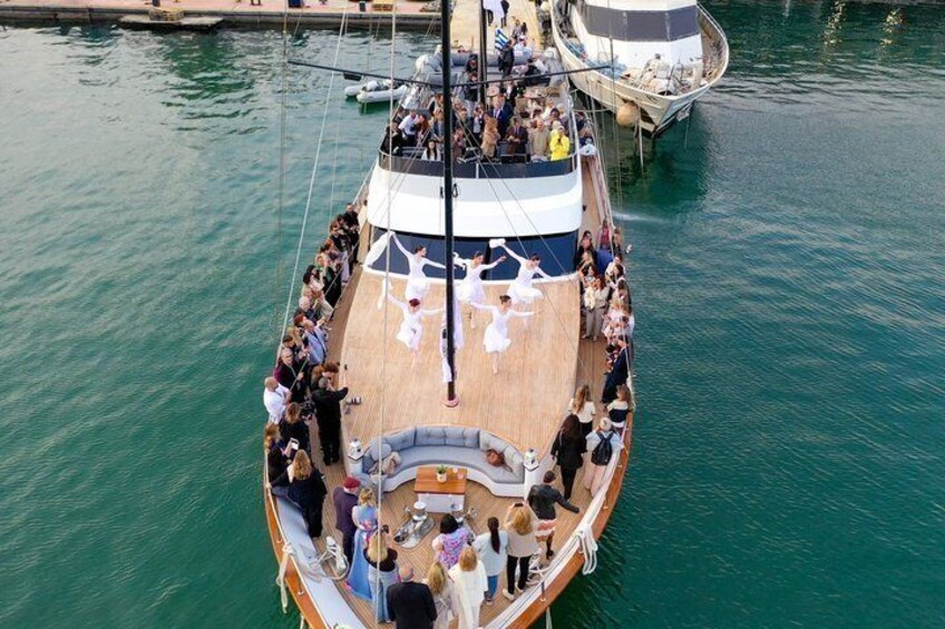 A boat with people on deck, some standing and others seated, with a clear view of the water. 2