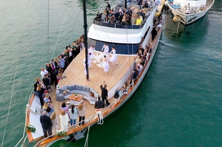 A large boat with a deck party, surrounded by calm water. 3