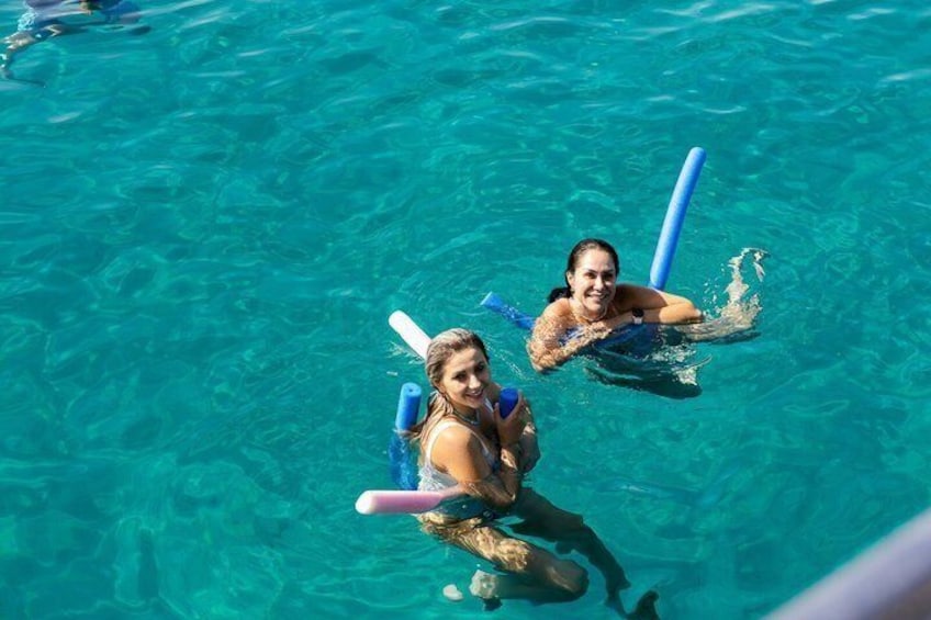 Two people swimming in clear blue water with snorkels and fins. 3
