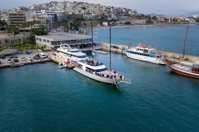 A marina with several boats docked, a building with a sloped roof, and a hilly urban backdrop. 5
