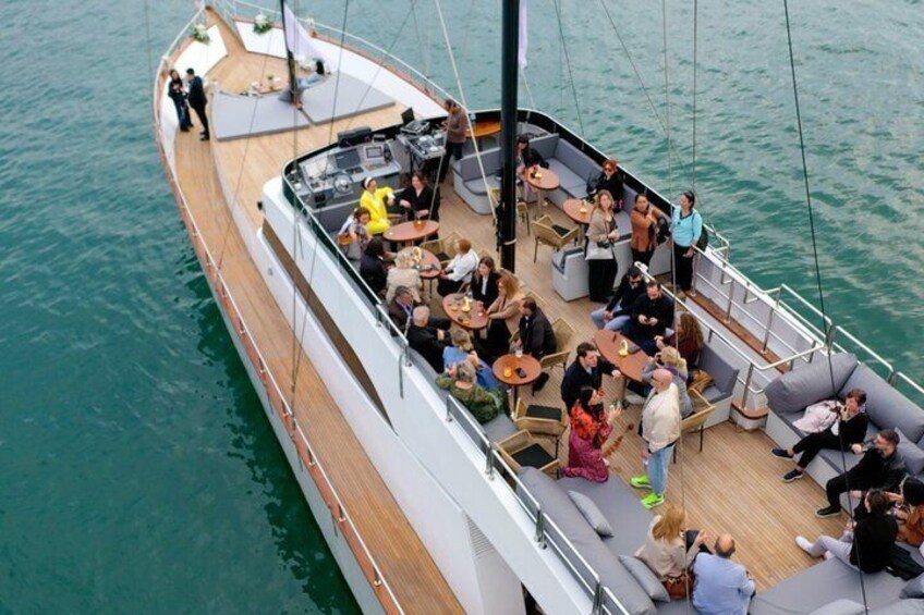 A boat with people dining and socializing on deck. 5