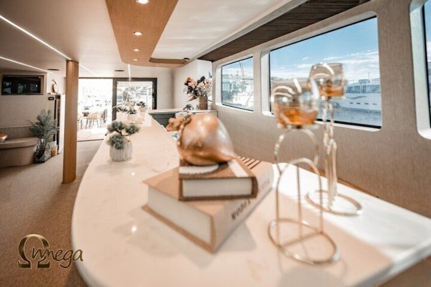 A modern interior with a curved white table, a book, a glass sculpture, and a view of the water outside. 2