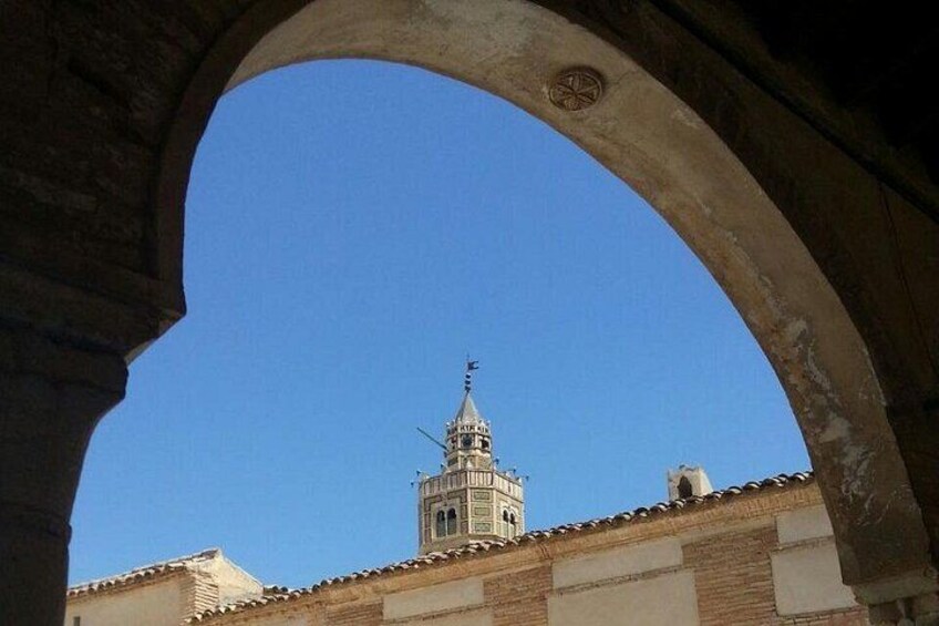A clear blue sky, a bell tower, and an archway. 5