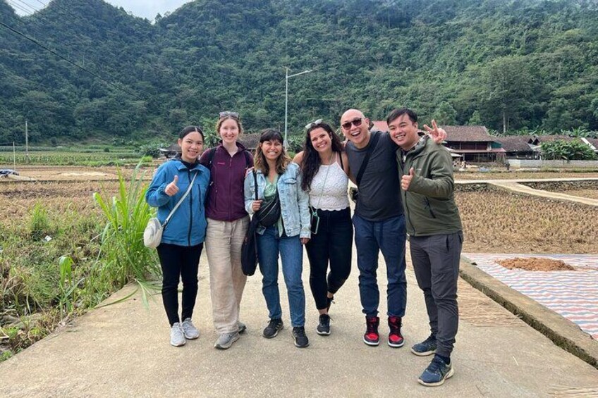 Un grupo de personas de pie sobre un sendero de hormigón con un paisaje rural al fondo. 2