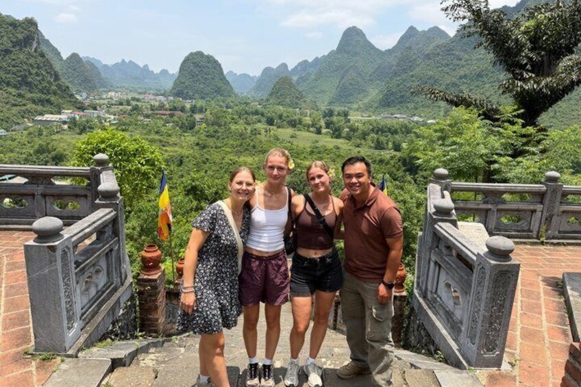 A group of people standing on a stone platform with a mountainous landscape in the background. 5