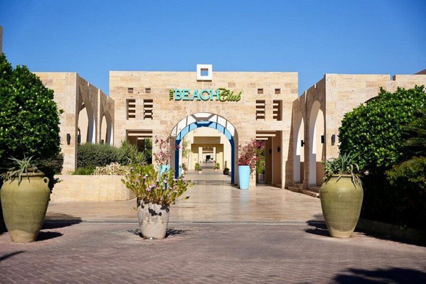 A building with a sign reading 'Beach Club' and an arched entrance. 3