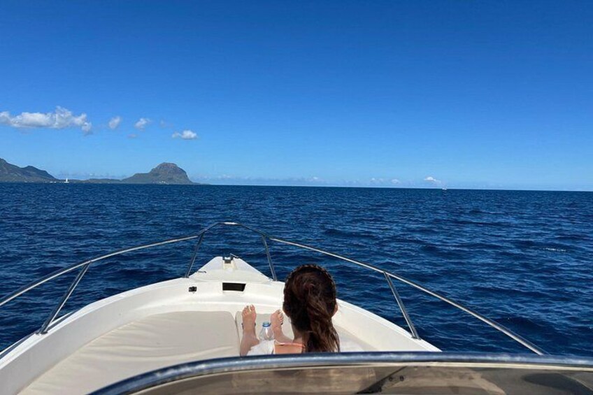 A boat on the ocean with a person holding a bottle. 5