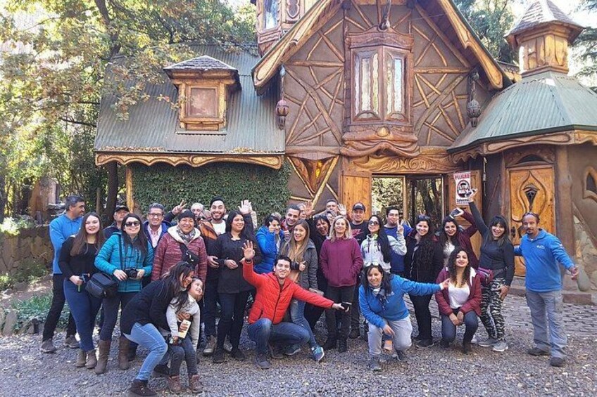 A group of people posing in front of a rustic wooden building with a green roof and a sign that reads 'SANCAL.' 4