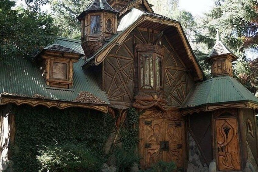 A wooden house with intricate carvings and a green roof. 5