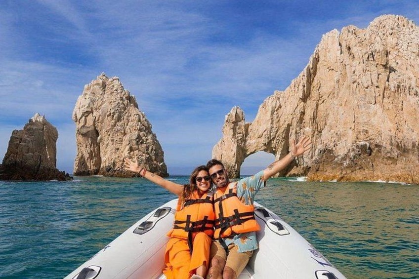 Two people in a boat with a rocky coastline in the background. 1