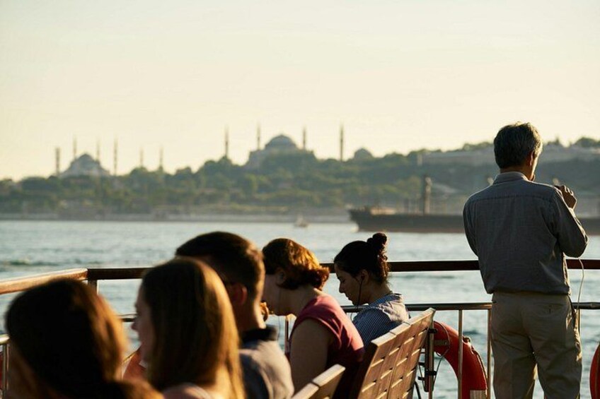 People on a boat, a city skyline in the background, and a body of water. 3