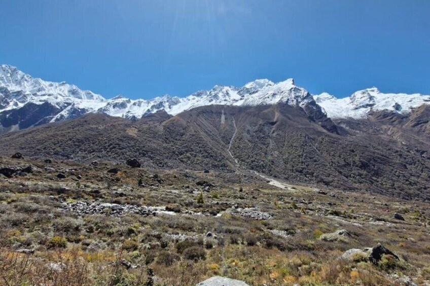 A mountainous landscape with snow-capped peaks and a clear sky. 4