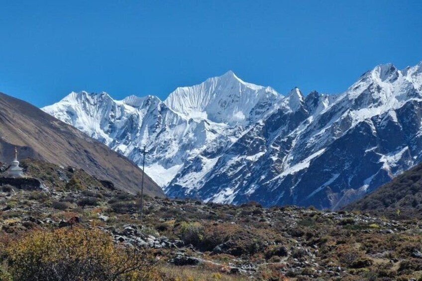 A mountain range with snow-capped peaks and a clear blue sky. 2
