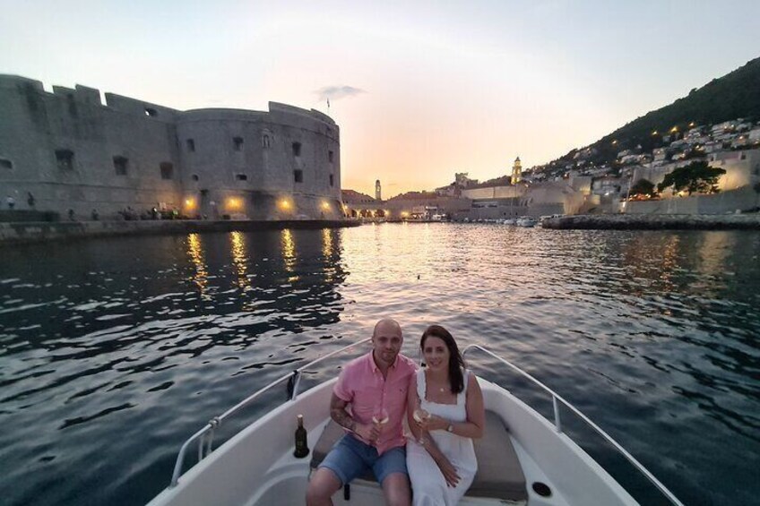 A boat on a body of water with a historic fort in the background. 4