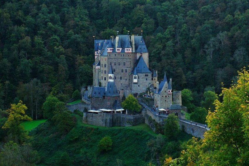 A castle surrounded by forested hills. 1
