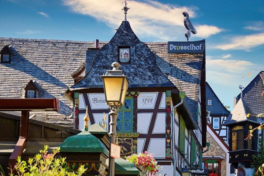 A traditional half-timbered building with a sign reading 'Drosselhof' and a street lamp in front. 3