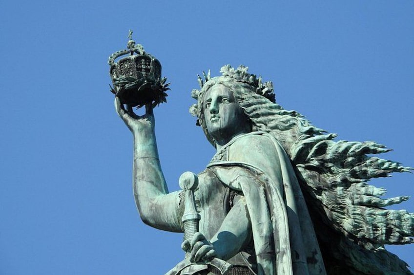 A statue of a figure holding a crown. 4