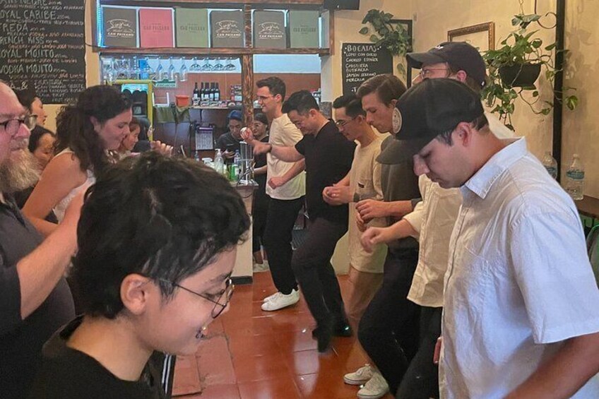 A group of people in a restaurant with a menu board in the background. 1