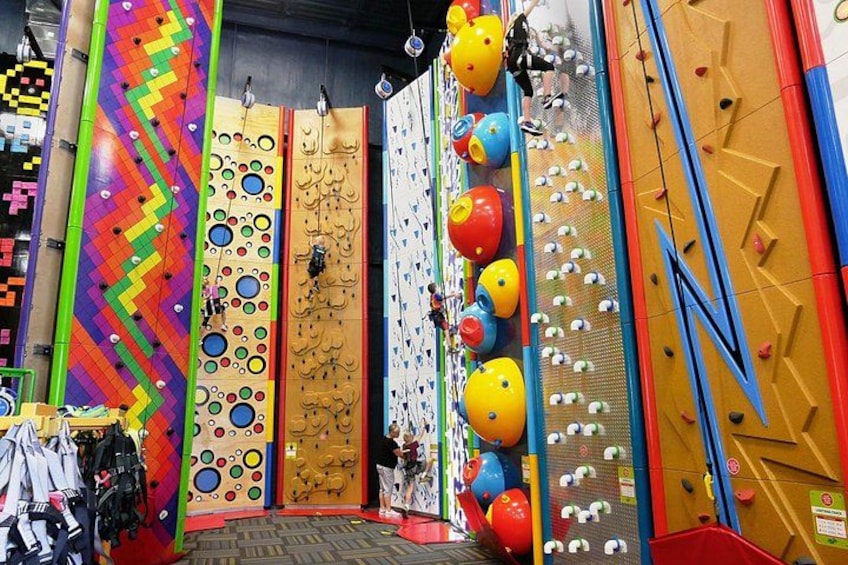 A climbing wall with colorful panels and various climbing holds. 3