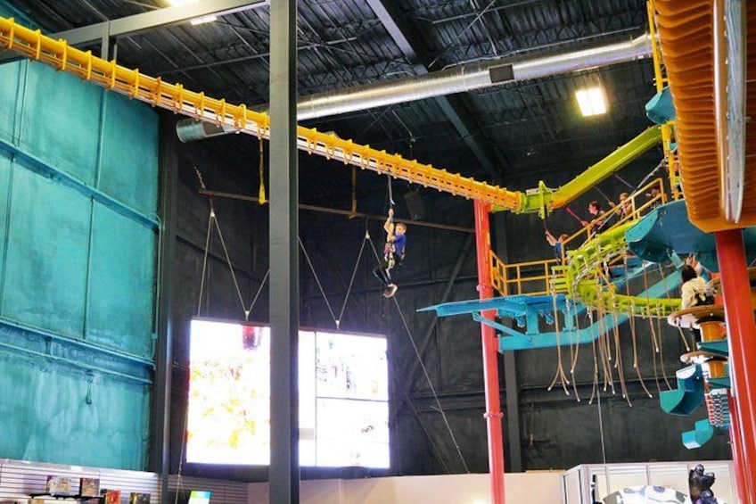 An indoor zip-lining course with multiple platforms and a central zip line. 3