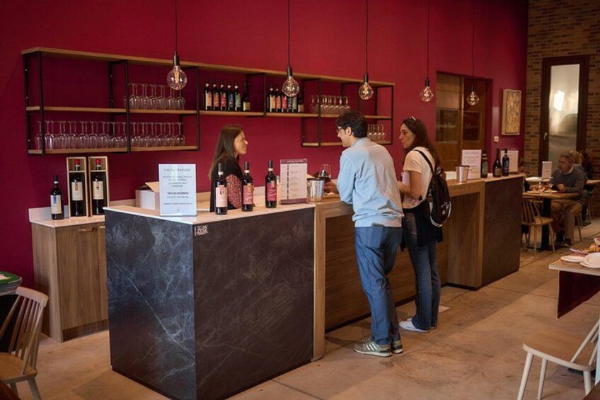 Eine Bar mit Marmorplatte, Flaschenregalen und hängenden Lampen. 3