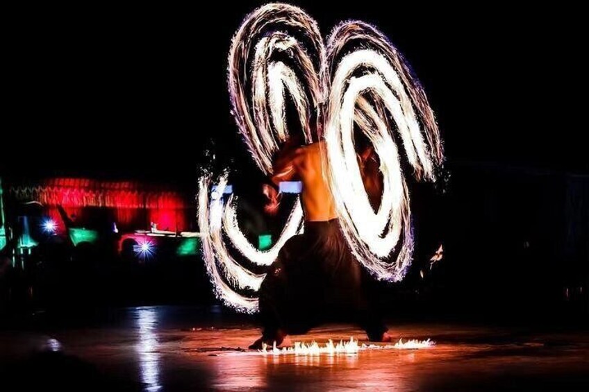 A person performing a fire spinning act with a fire poi. 3