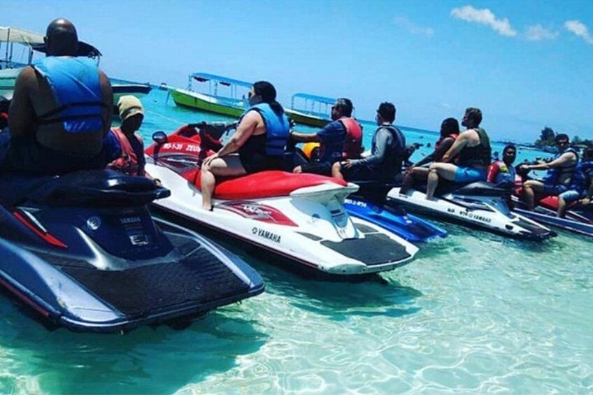 Jet skis on water with people wearing life jackets. 3