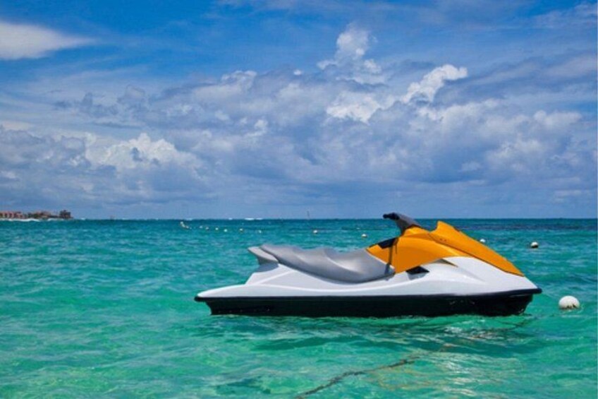 A jet ski on turquoise water with a clear sky and distant land. 2