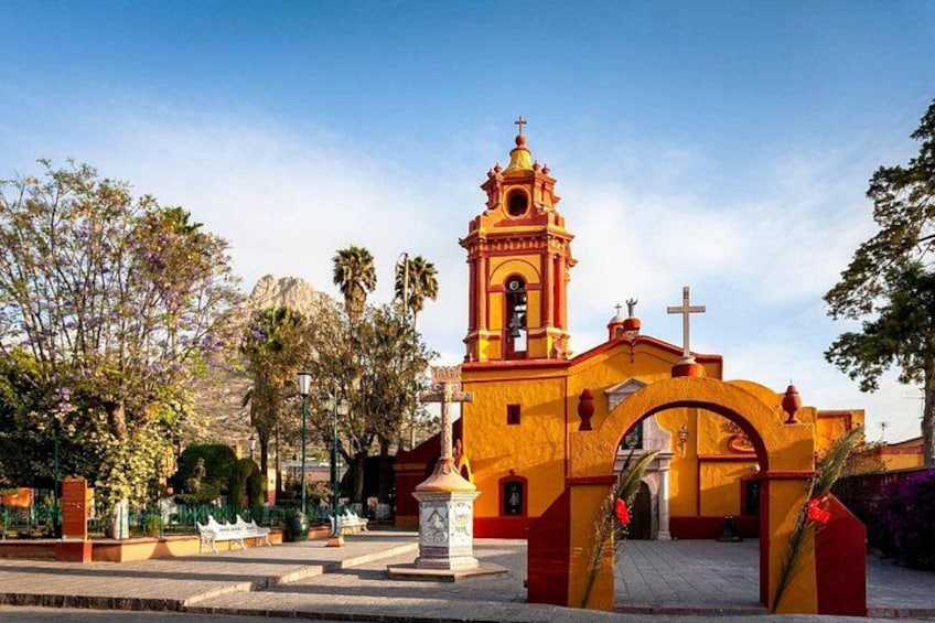 A church with a bell tower, an archway, and a statue. 4