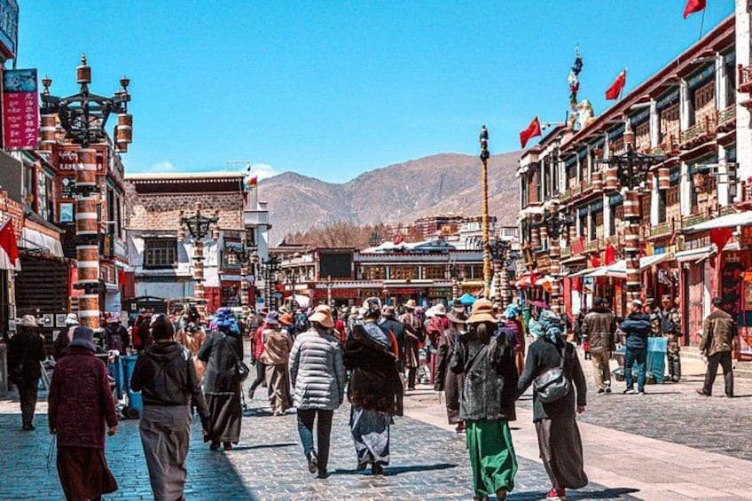 A bustling street with people walking, traditional buildings, and flags. 4
