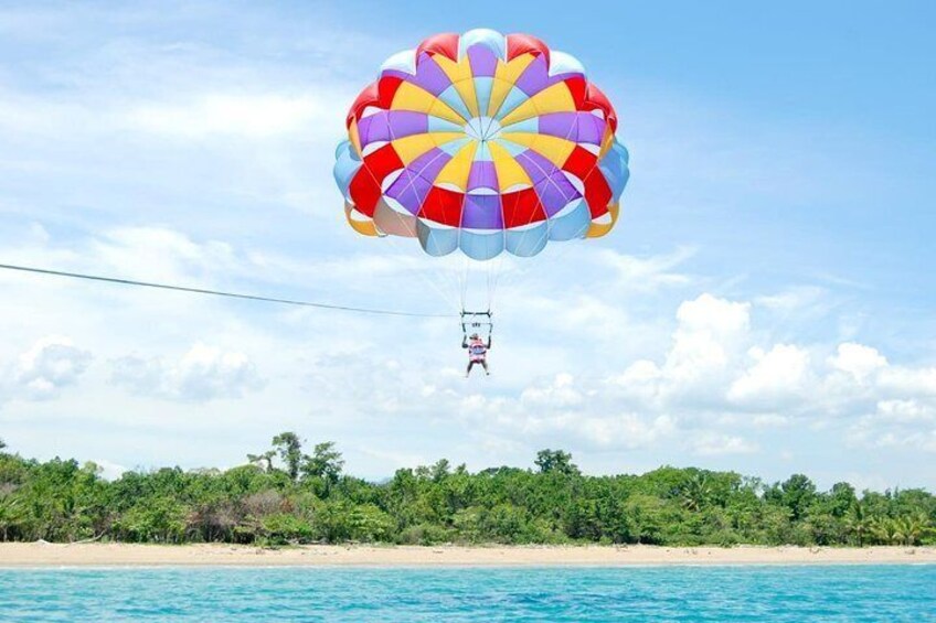 A person parasailing over a beach with a colorful parachute. 3