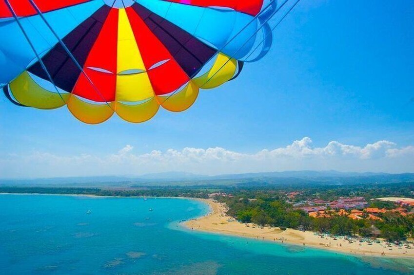 A hot air balloon over a coastal landscape with clear skies, turquoise waters, and a beach. 2