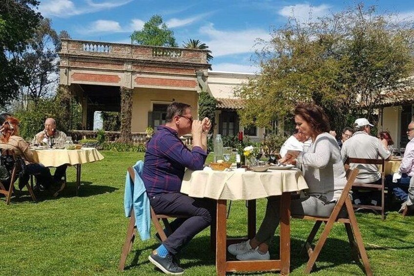 People dining outdoors at tables with a building in the background. 4