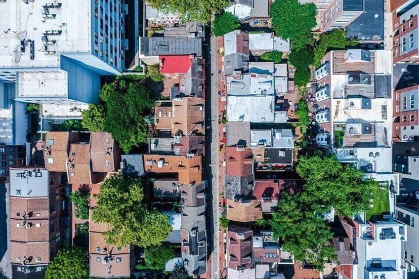 An aerial view of a densely packed urban area with buildings, trees, and narrow streets. 4