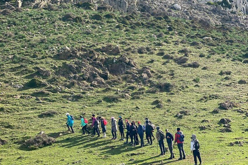 A group of people standing on a grassy hillside. 4