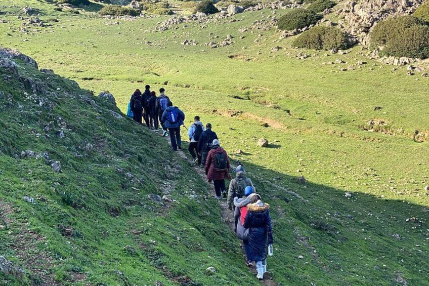 A group of hikers on a grassy hillside. 3