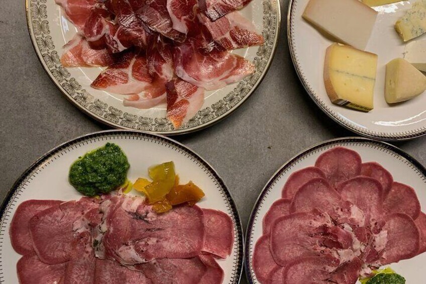Four plates of food, including sliced meats and cheese. 5