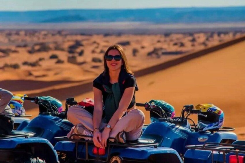 A person sitting on a quad bike in a desert landscape. 2