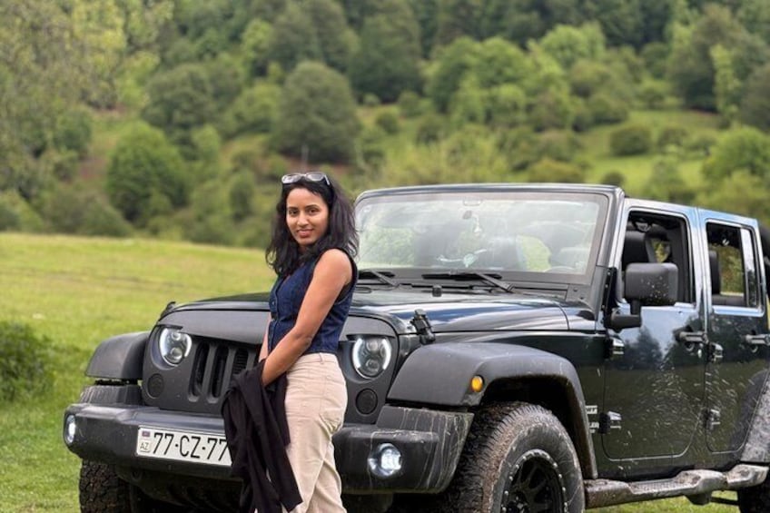 A black off-road vehicle parked in a grassy field with trees in the background. 4
