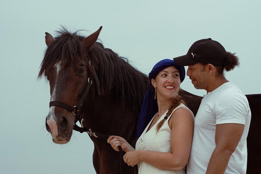 A person with a horse, a horse's head, and a person wearing a cap. 5