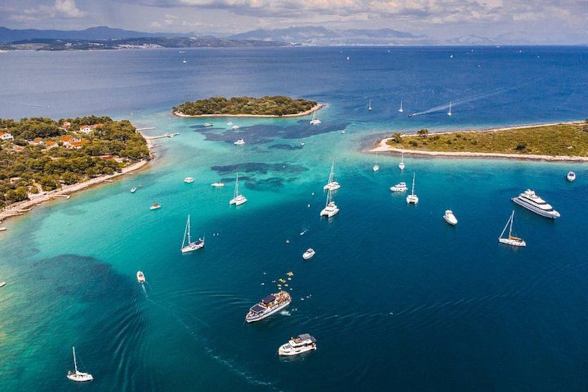 A coastal area with clear turquoise waters, several boats, and small islands. 1
