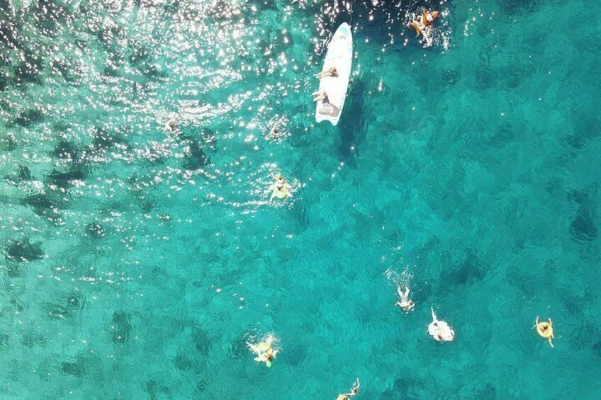 A boat on turquoise water with a clear sky. 4