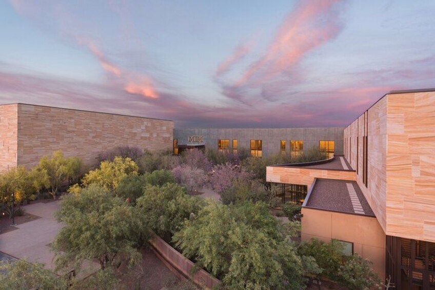 Un edificio moderno con un patio rodeado de árboles y arbustos. 2