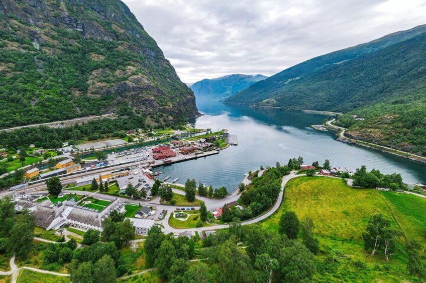 A mountainous landscape with a lake, a marina, and a small town with buildings and greenery. 2