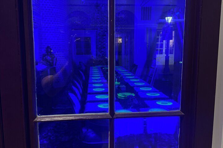 Una habitación con una mesa larga iluminada por luces azules. 5