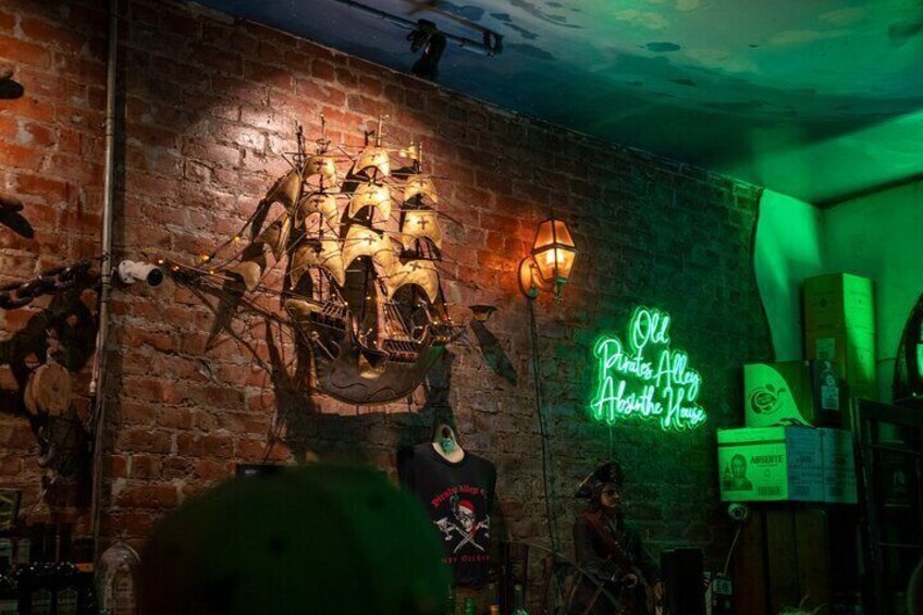 Un muro de ladrillo con una gran escultura de barco, un letrero de neón y varias decoraciones. 3