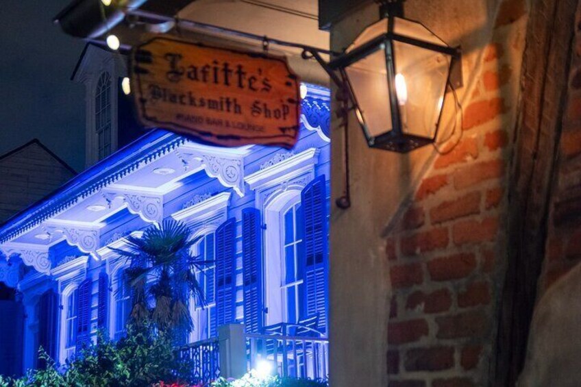 A building with a sign reading "Garitte's Blacksmith Shop" and a blue-lit facade. 1