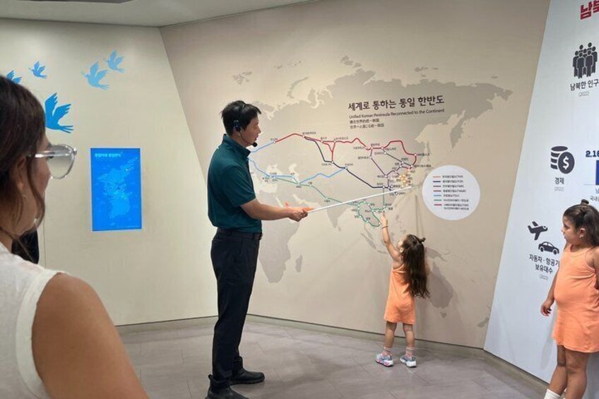 A person presenting a map to a child in a museum. 2