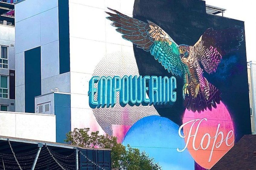 Et stort udendørs muralmaleri med en ørn og ordene 'EMPOWERING' og 'Hope' på en bygning. 5